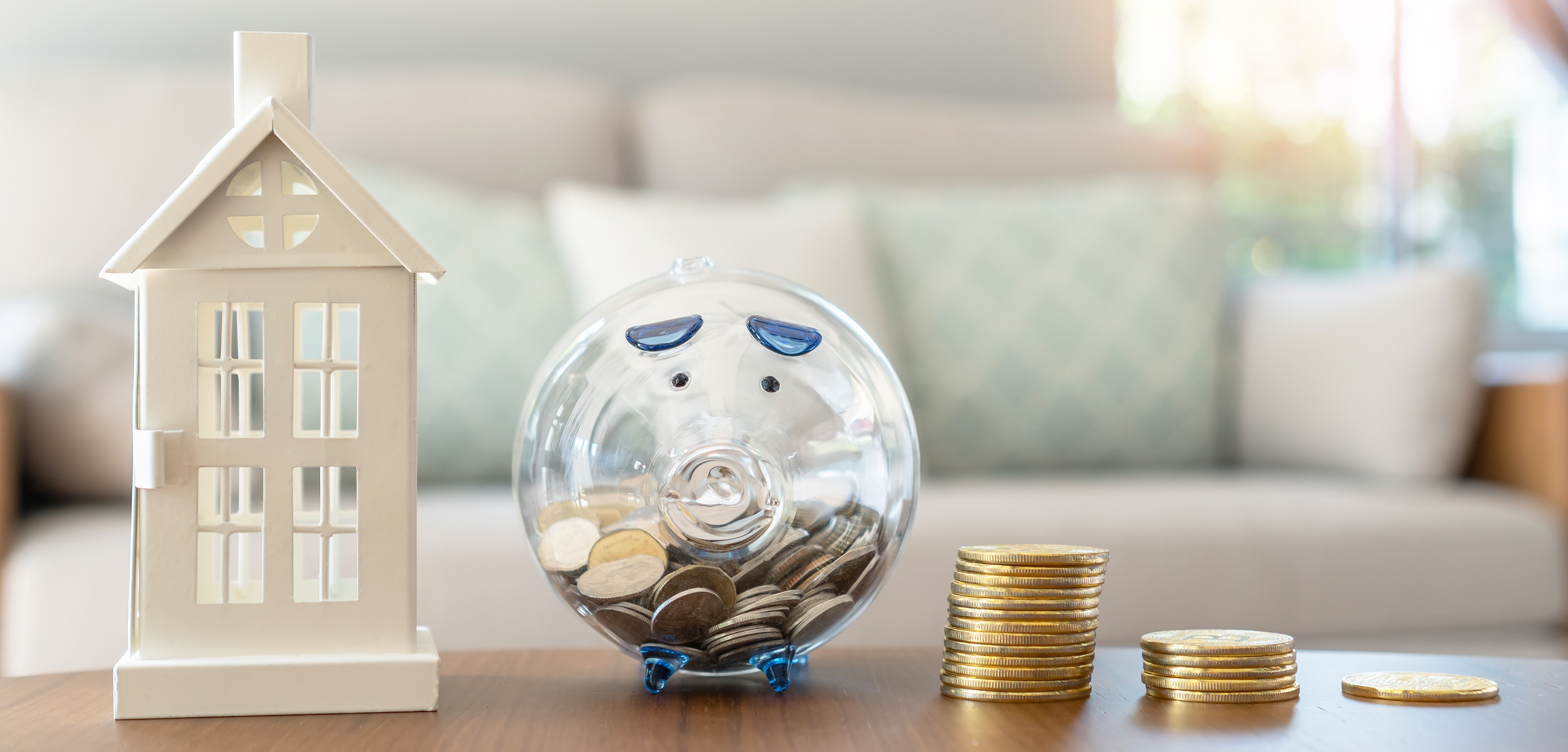 Piggy bank, coins, and house items representing Labor’s housing crisis initiatives