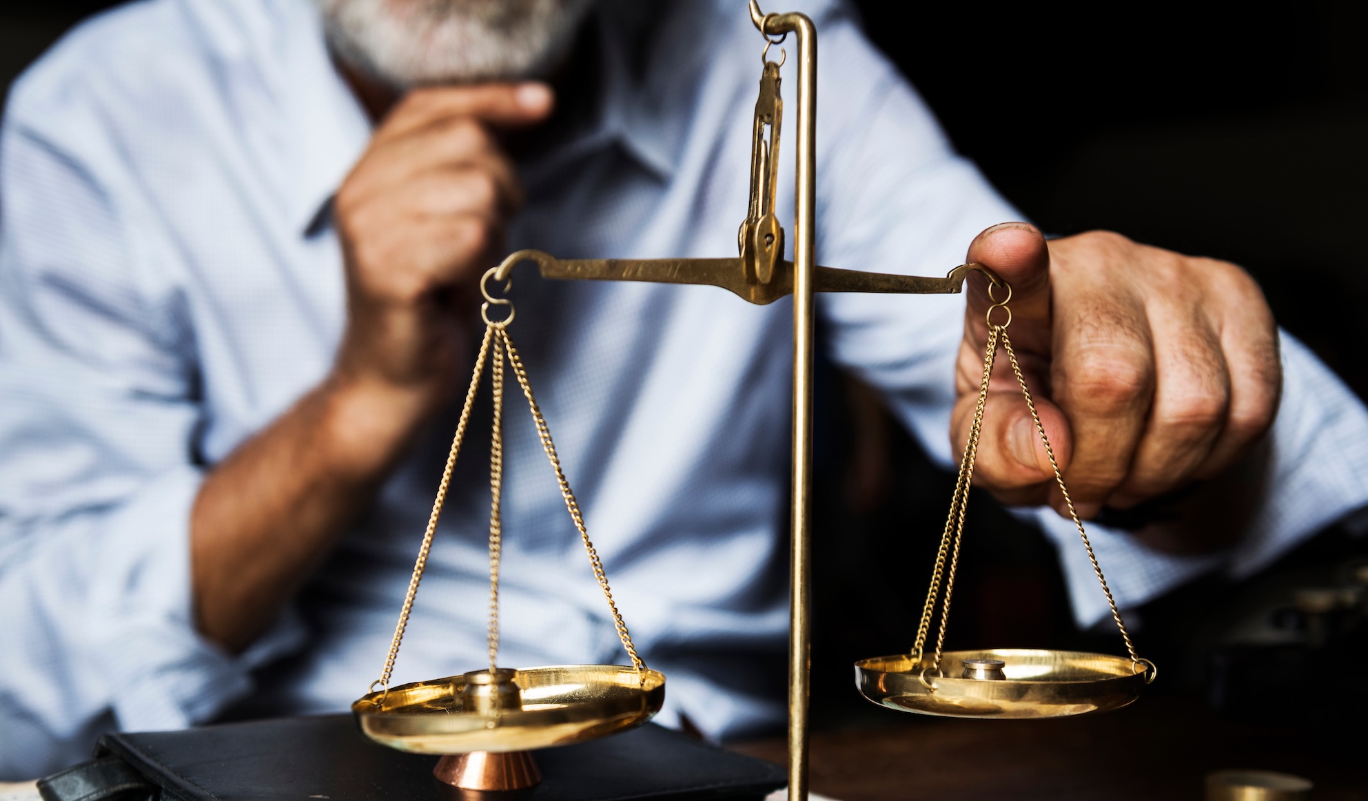 man tipping scales of justice