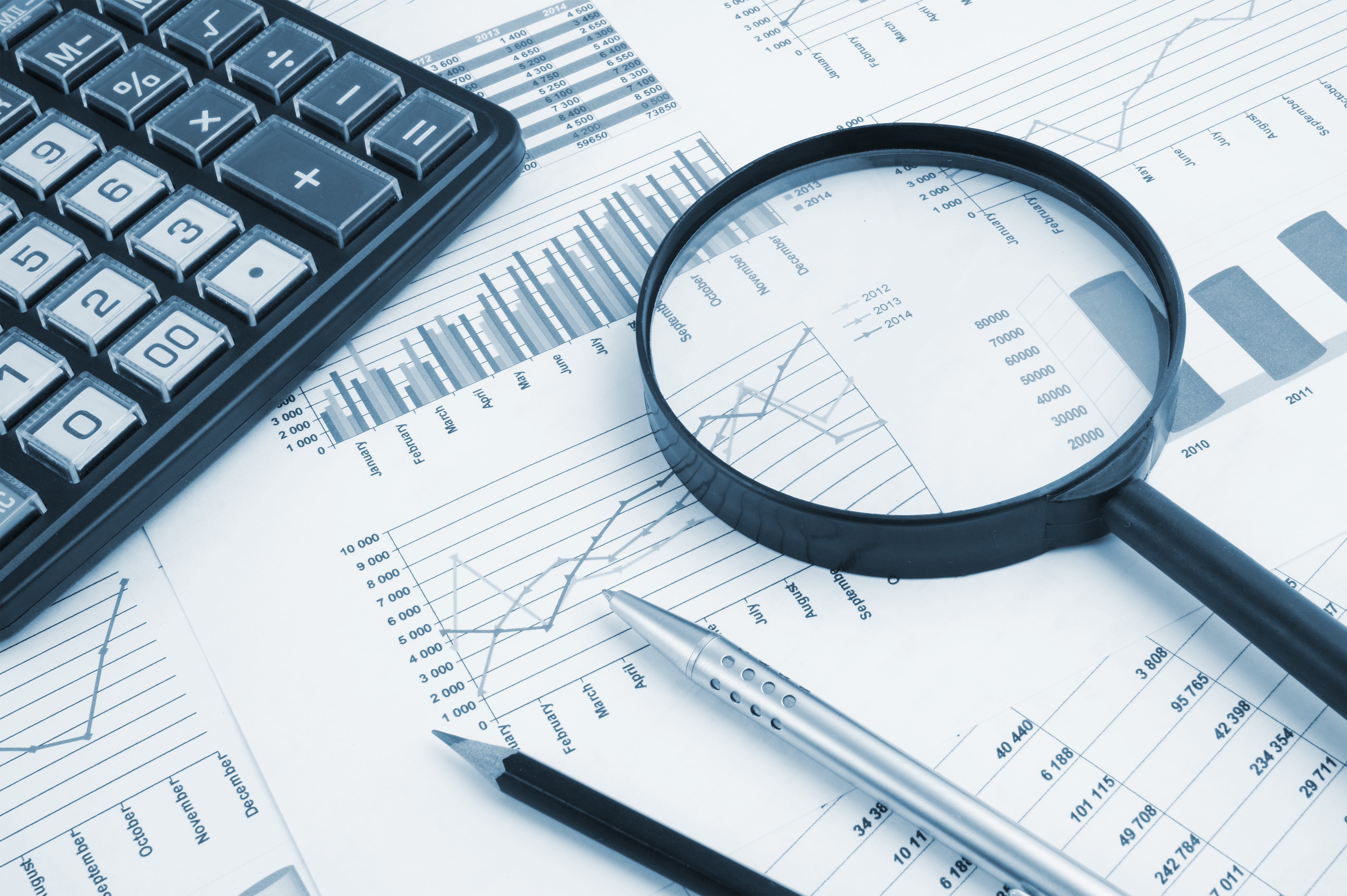 Magnifying glass over financial reports symbolising detailed disclosure required under public country-by-country reporting